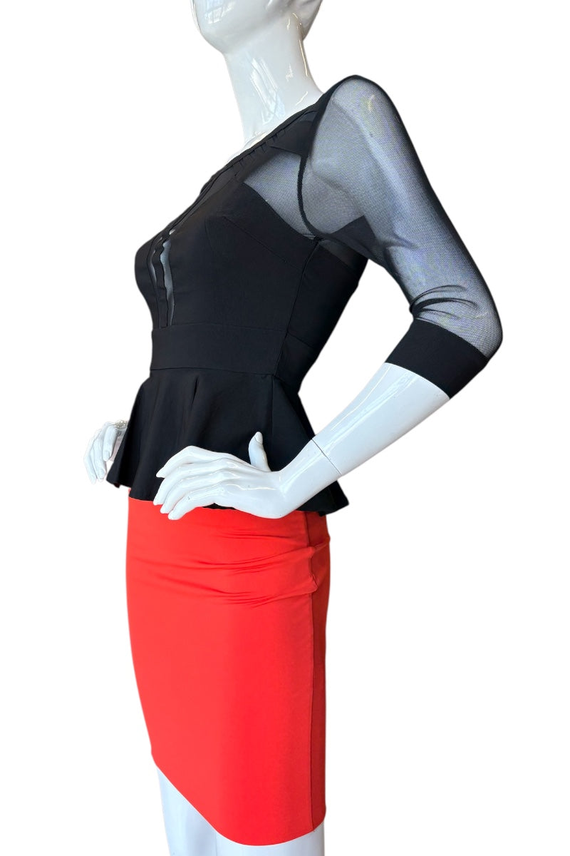 Mannequin wearing a black top with sheer sleeves and a red skirt on a white background