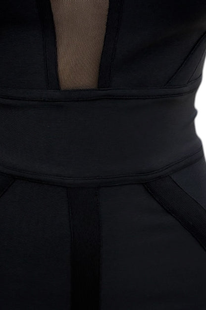 Close-up of a black dress with sheer mesh under the bust on a white background