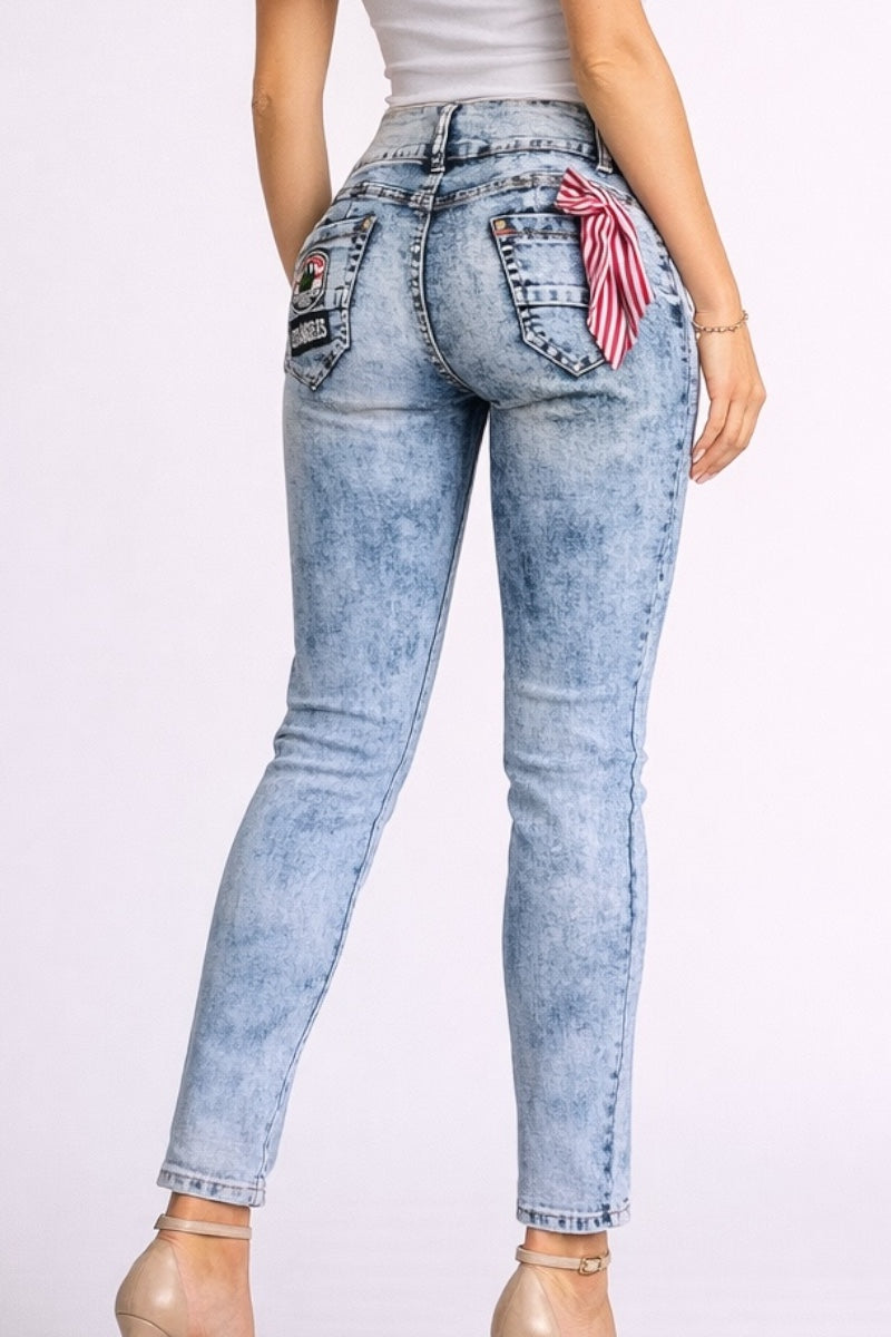 Light blue jeans with decorative patches on a white background