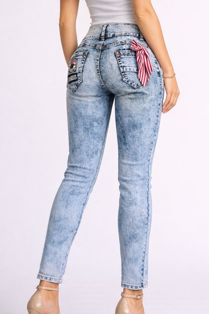 Light blue jeans with decorative patches on a white background