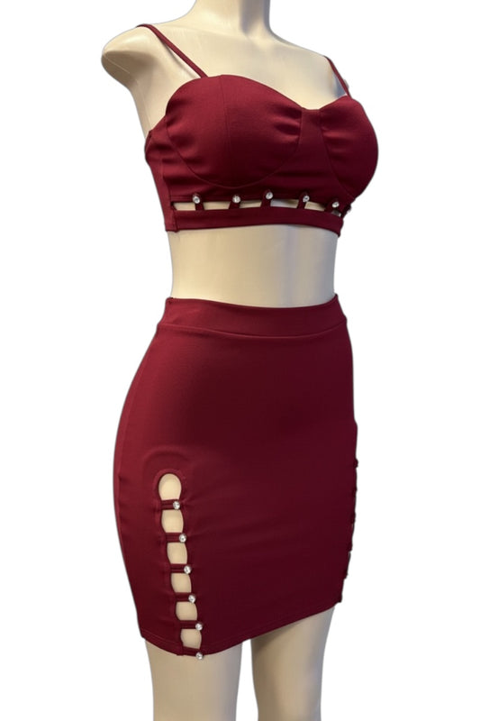 burgundy two-piece outfit with cut-out details on a mannequin against a white background