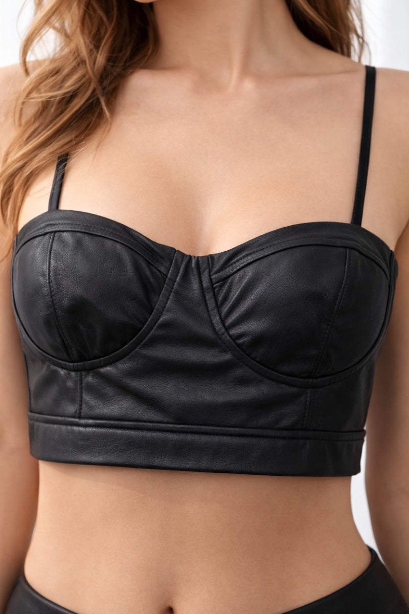 Black leather-style bralette top worn by a person on a neutral background