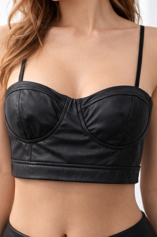 Black leather-style bralette top worn by a person on a neutral background