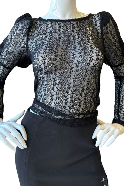 Mannequin wearing a black lace top and black skirt on a white background