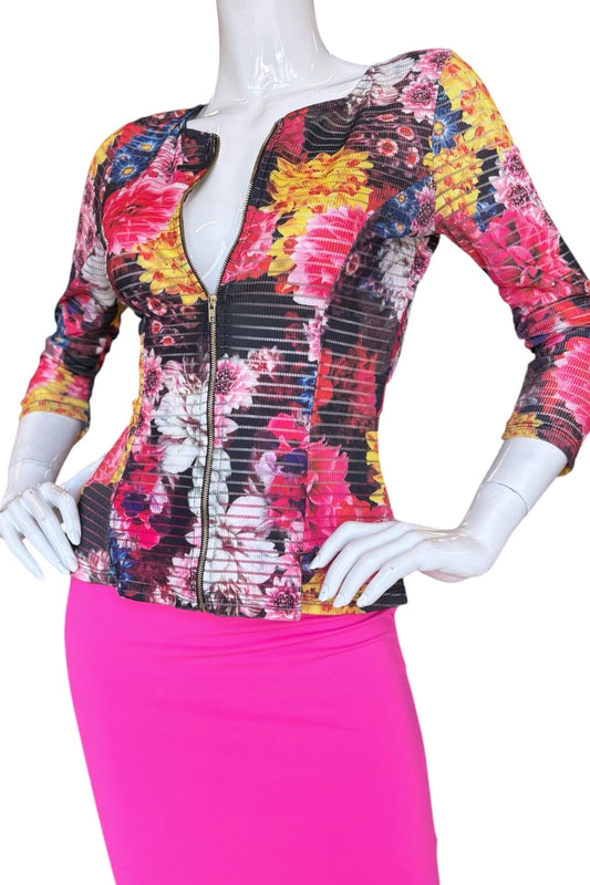 Mannequin wearing a colorful floral top and pink skirt against a white background