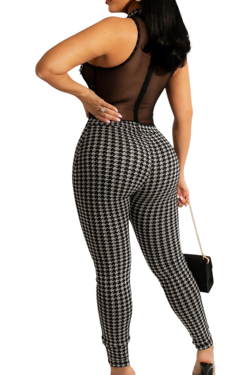 Person wearing a black and white houndstooth patterned jumpsuit on a white background