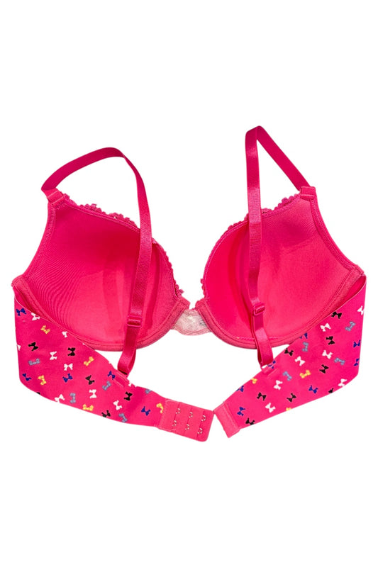 Pink bra with colorful bow pattern on straps against a white background