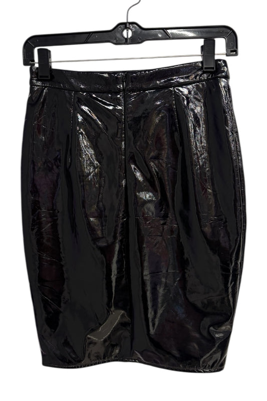 Black glossy skirt on a hanger against a white background