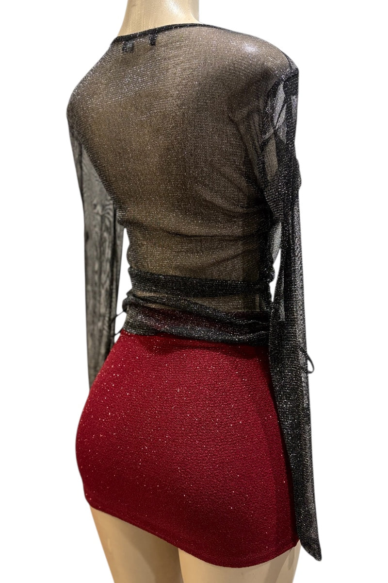 Mannequin wearing a sheer black top with red skirt on a white background