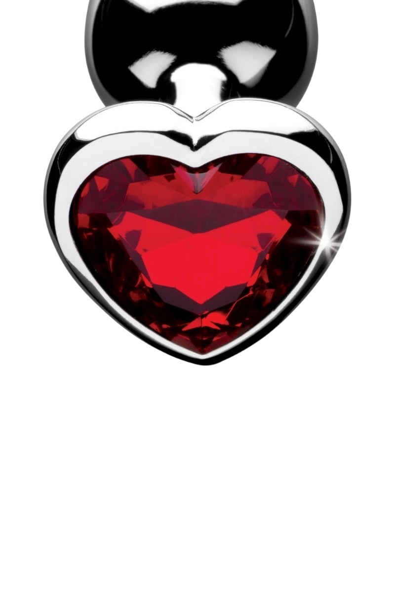 Heart-shaped plug with red gemstone on a white background