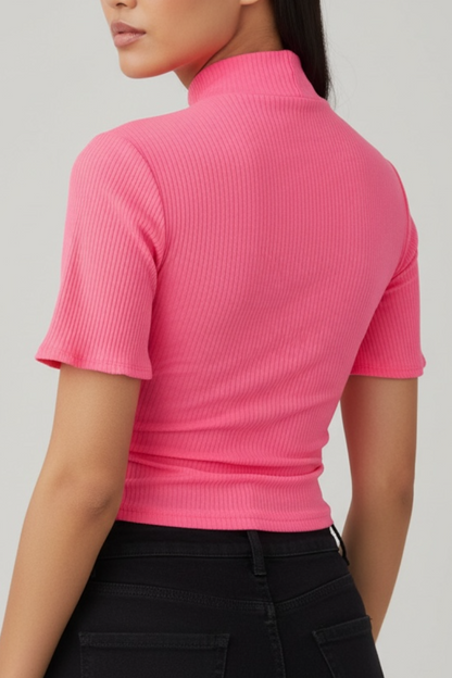 Person wearing a bright pink ribbed top against a light gray background