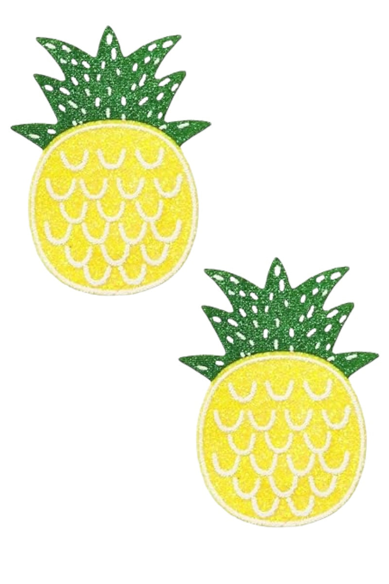 Two pineapple-shaped pasties with green leaves on a white background