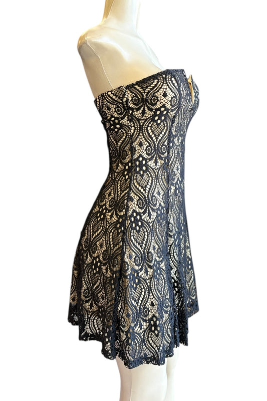 Black and nude patterned dress on a mannequin against a white background