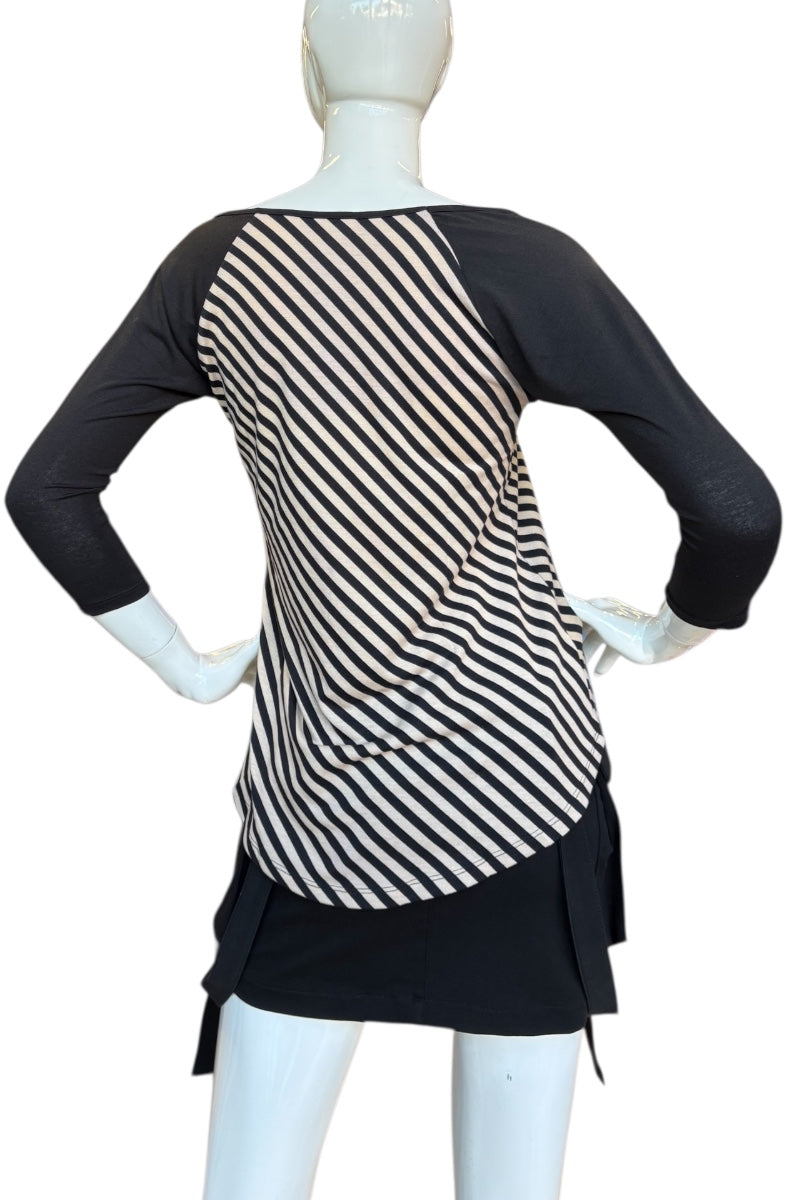 Mannequin wearing a black and beige striped top with a black dress on a white background