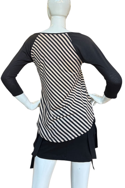 Mannequin wearing a black and beige striped top with a black dress on a white background