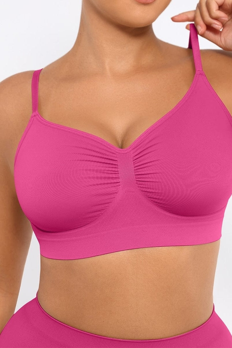 Person wearing a fuchsia bralette and panty against a white background