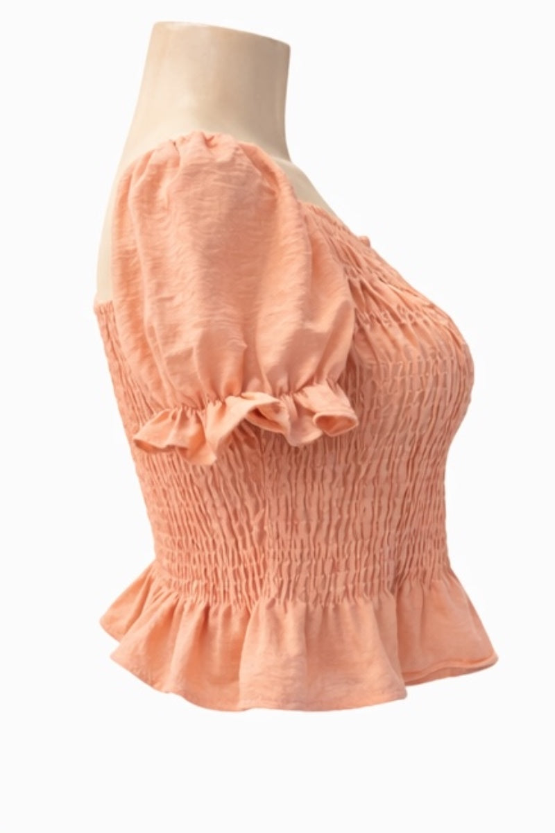 pink coral-colored top on a mannequin against a white background