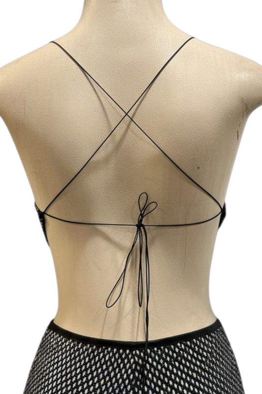 Black strappy top on a mannequin with a white background