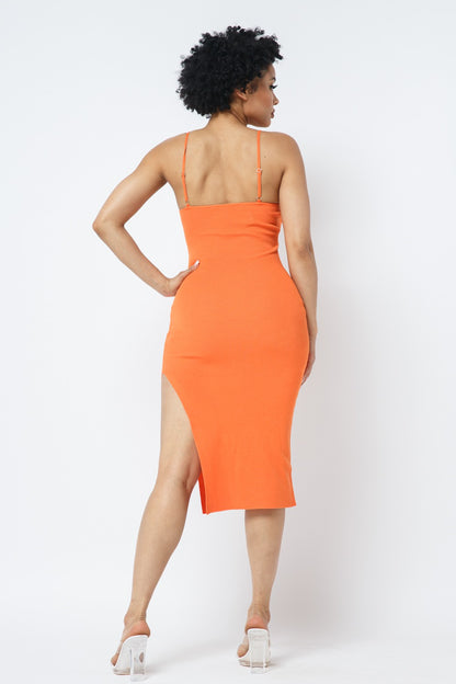 Woman wearing an orange dress with a slit on a white background