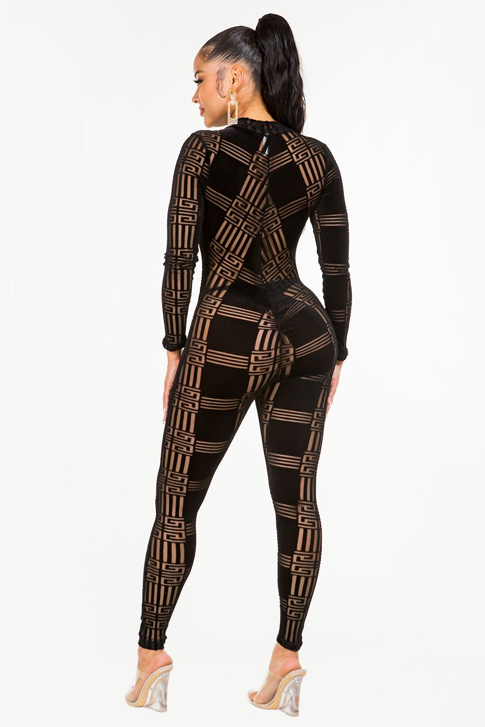 Woman wearing a black velvet patterned jumpsuit on a white background
