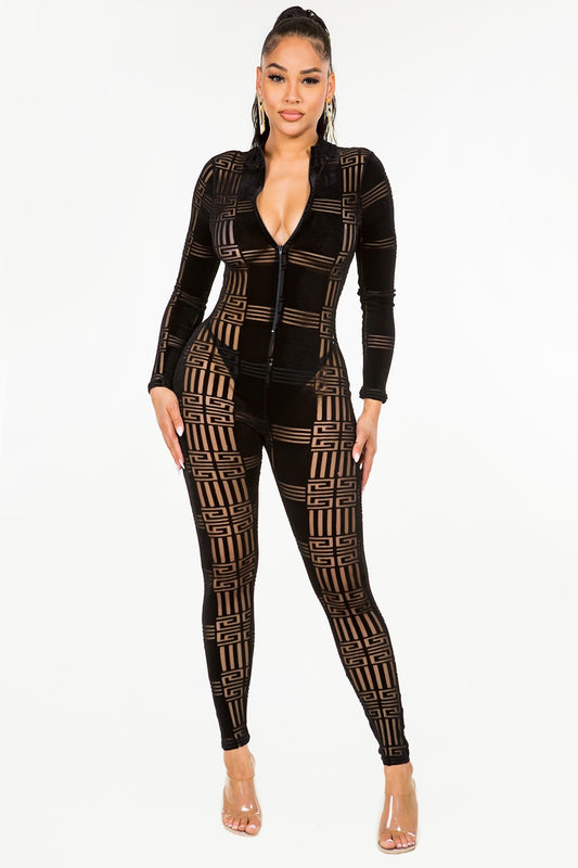 Woman wearing a black velvet patterned jumpsuit on a white background