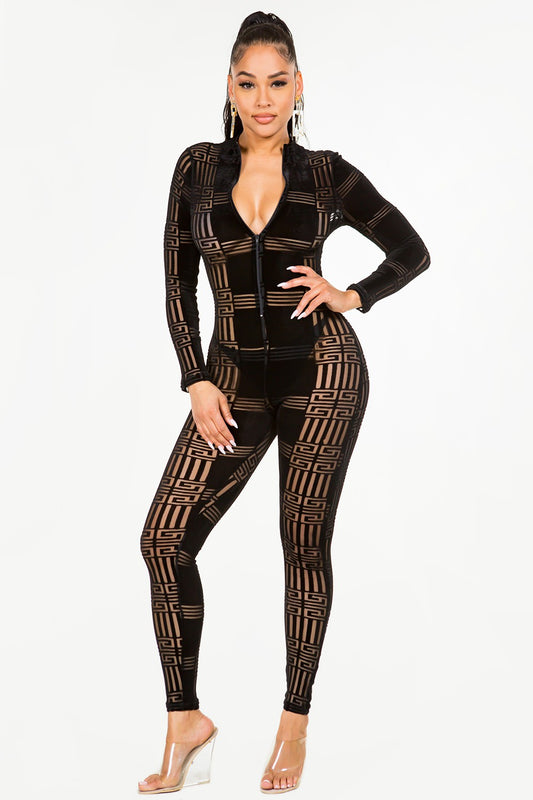 Woman wearing a black velvet patterned jumpsuit on a white background
