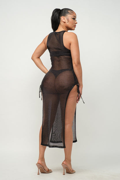 Woman wearing a sheer black dress with a high slit on a white background