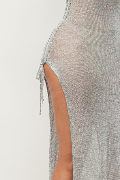 Close-up of a textured silver dress with a side slit on a light gray background