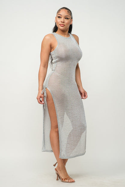 Woman wearing a silver halter neck dress with a slit on a white background