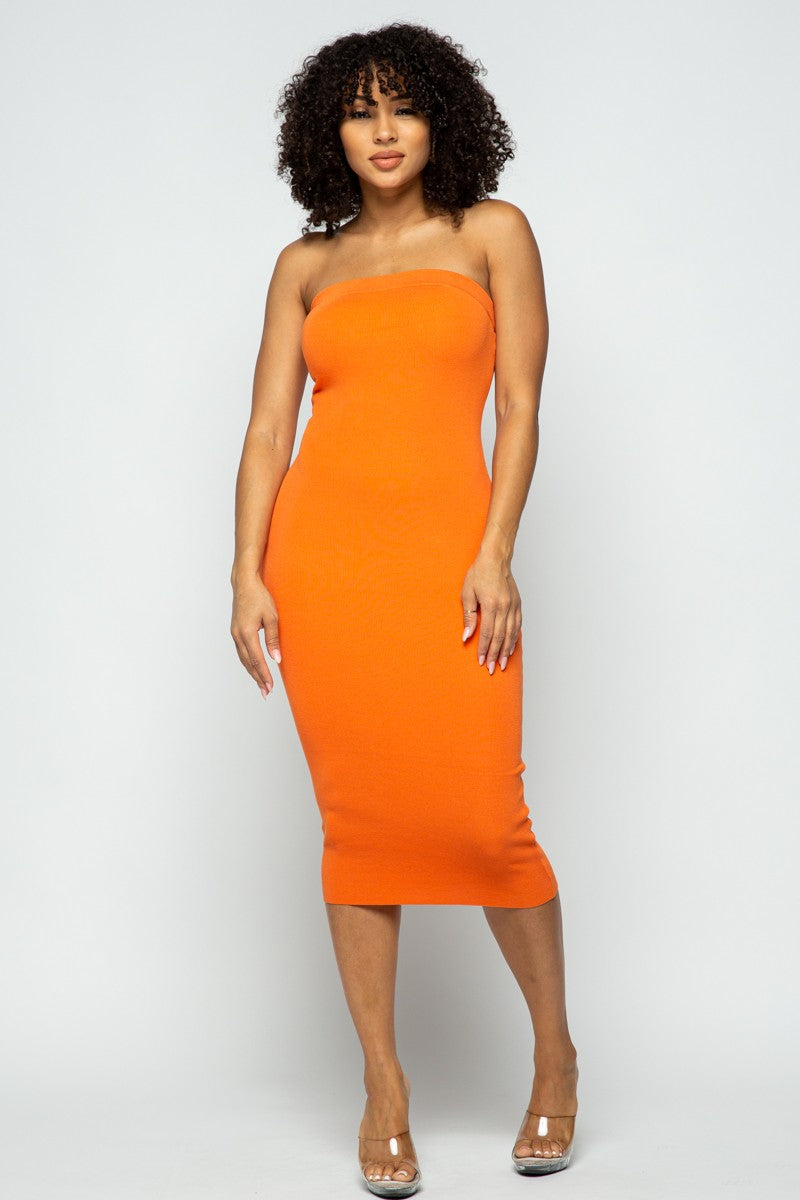 Woman wearing an orange strapless dress against a white background