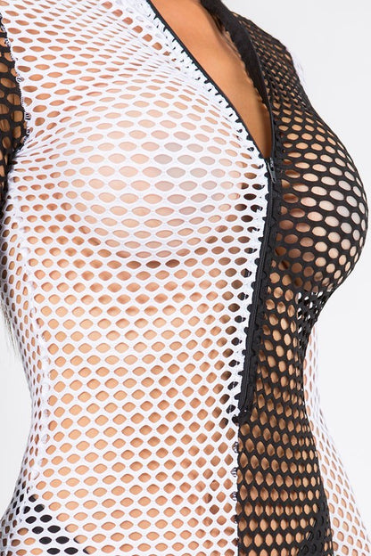 Close-up of a black fishnet bodysuit with a deep V-neckline and open mesh panels over a white undergarment, shown on a model against a light gray background.