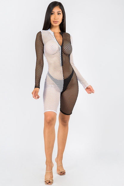A woman modeling a long-sleeve, bodycon romper made of black and white fishnet mesh, shown against a plain light gray studio background.