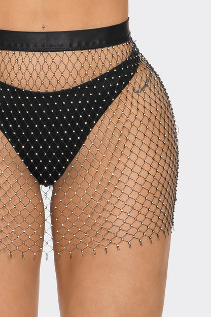 Woman wearing a studded fishnet skirt on a white background