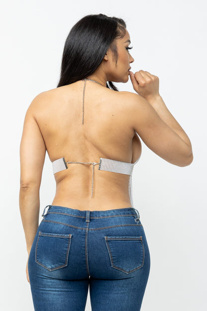 Woman wearing a strappy top and blue jeans on a white background