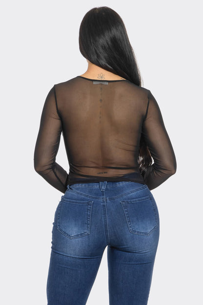 Person wearing a sheer black top and blue jeans on a white background