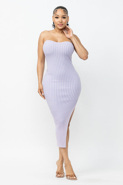 Woman wearing a lavender strapless dress with a high slit on a white background