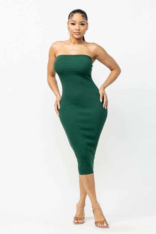 Woman wearing a hunter green strapless dress on a white background