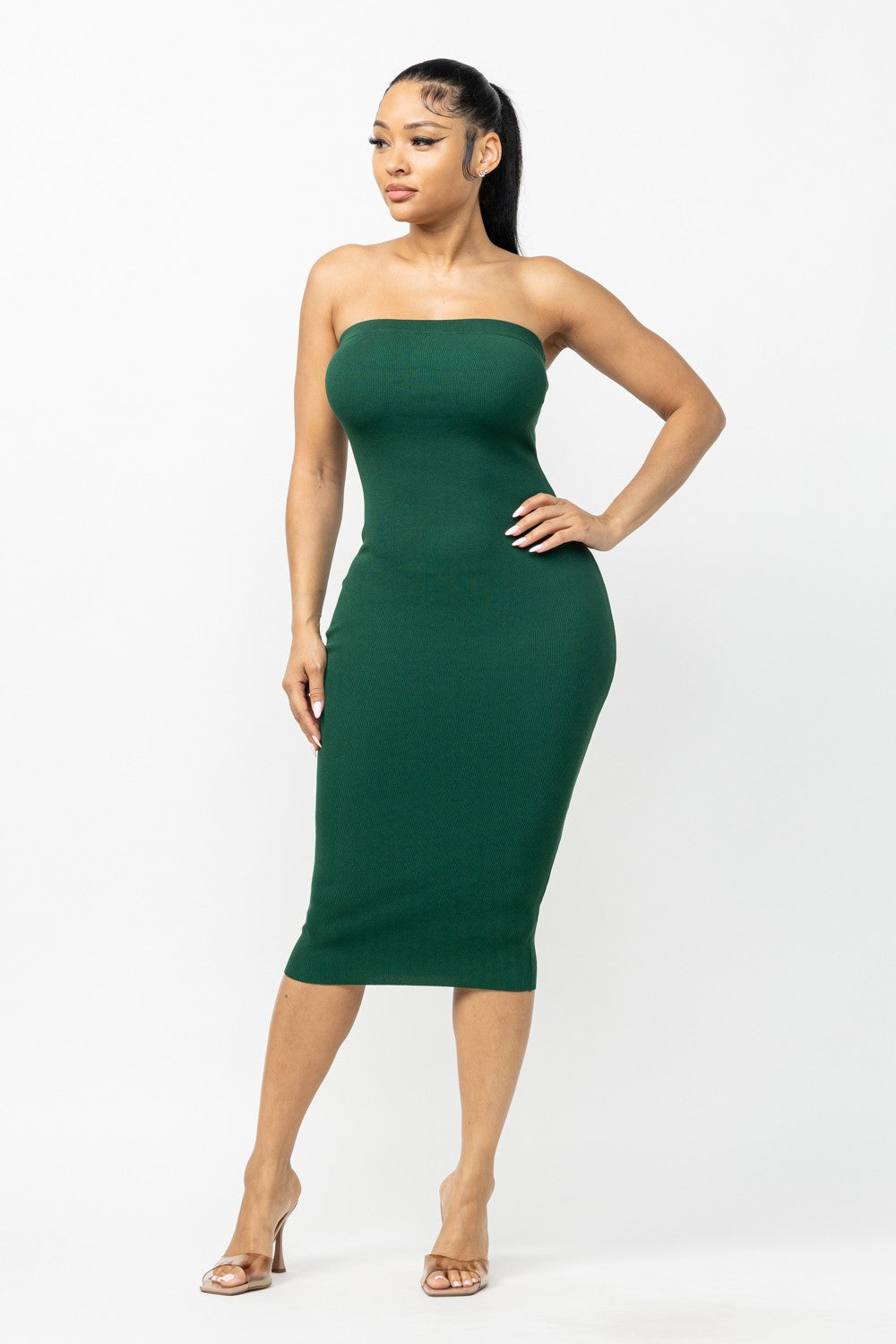 Woman wearing a hunter green strapless dress on a white background
