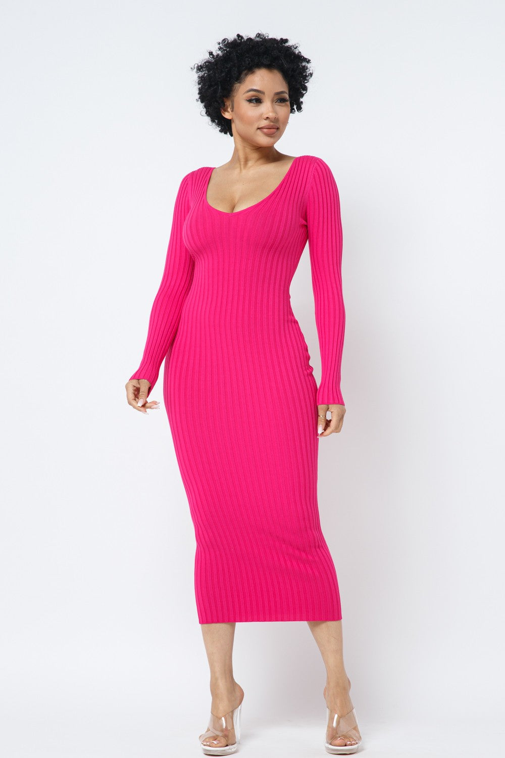 Woman wearing a fuchsia pink ribbed dress against a white background