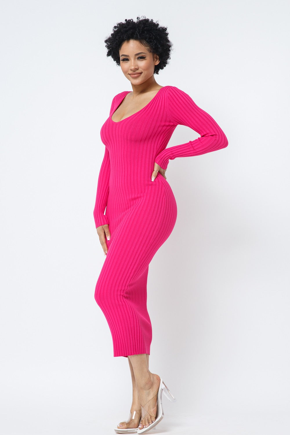 Woman wearing a fuchsia pink ribbed dress on a white background