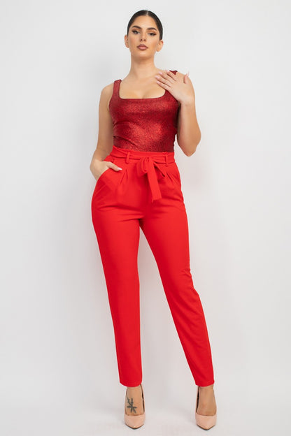 Woman wearing a red top and pants on a white background