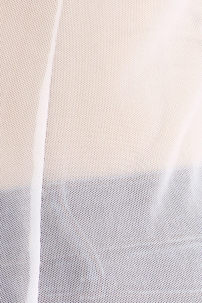 Close-up of a white fabric over a beige and blue outfit. 