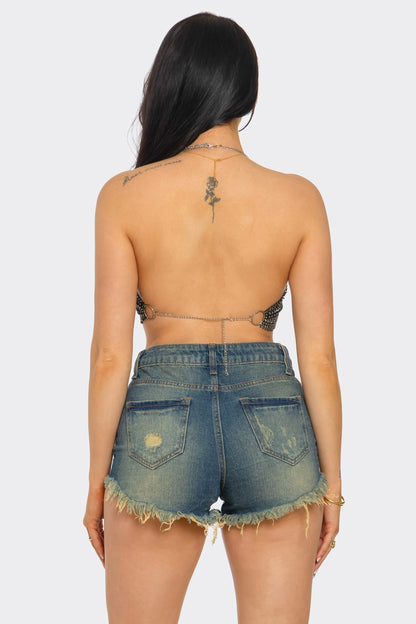 Person wearing a strapless top and denim shorts on a white background