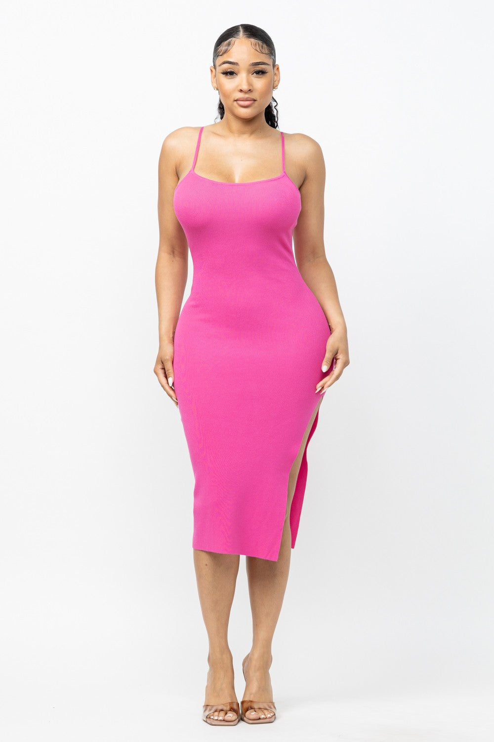 Woman wearing a fuchsia pink dress with a slit on a white background