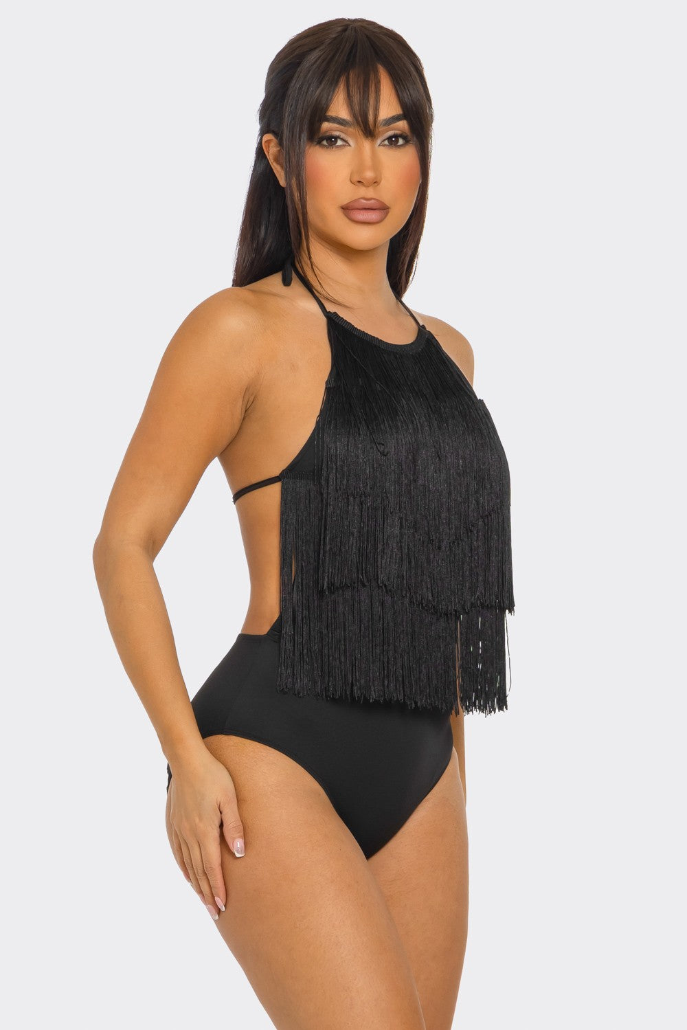 Woman wearing a black fringed bodysuit against a white background