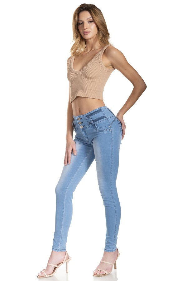 Woman wearing a beige top and light blue jeans on a white background