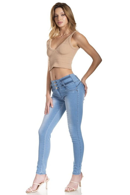 Woman wearing a beige top and light blue jeans on a white background