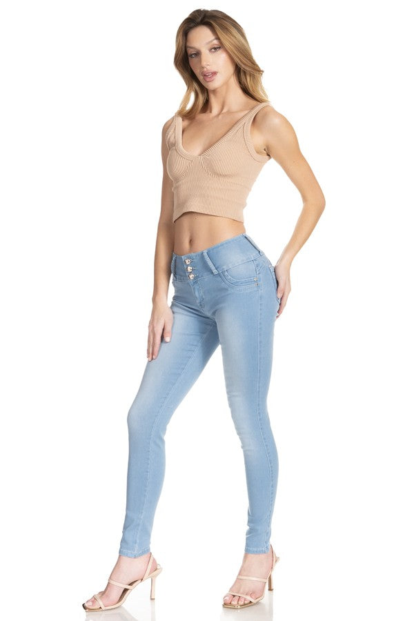 Woman wearing light blue jeans and a beige top on a white background