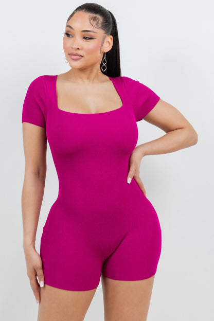 Woman wearing a magenta pink romper against a white background