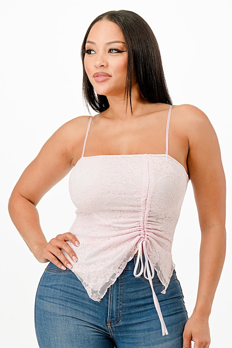 Woman wearing a light pink lace top and blue jeans on a white background